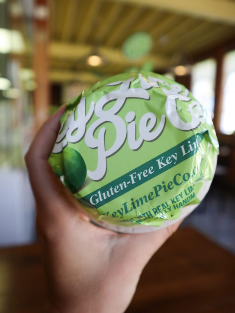 Sarah's hand holding the packaged key lime pie in a cup. The label reads gluten free key lime pie.