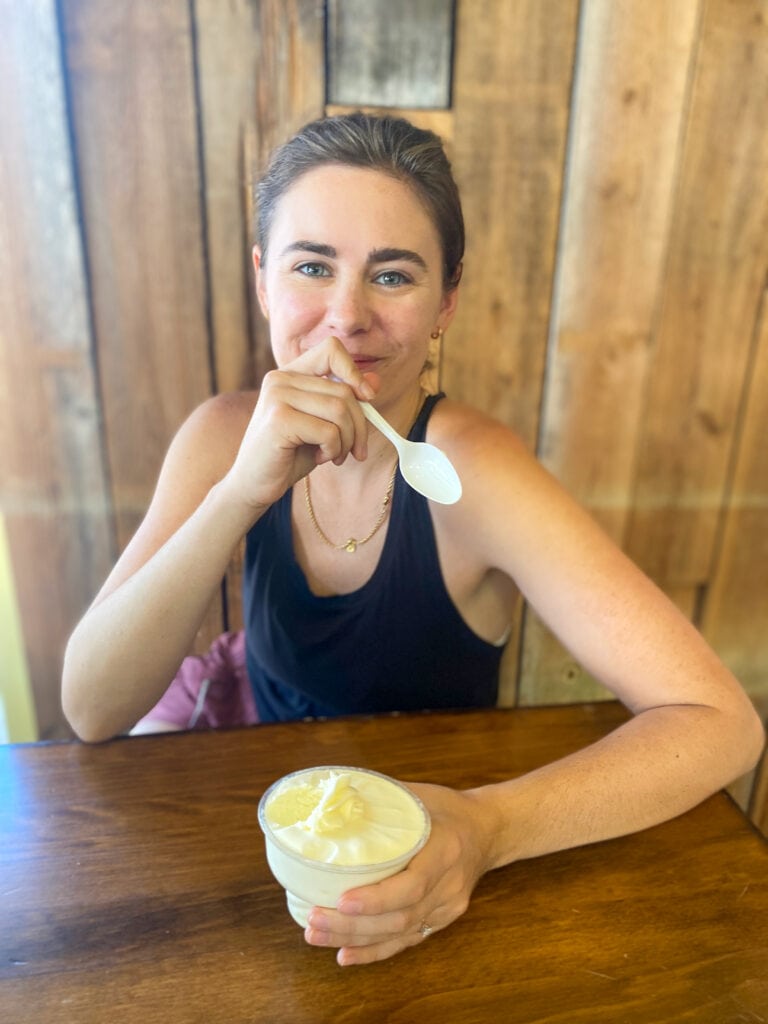 Sarah, a white woman with brown hair and a black tank top, takes a bite of pie filling.