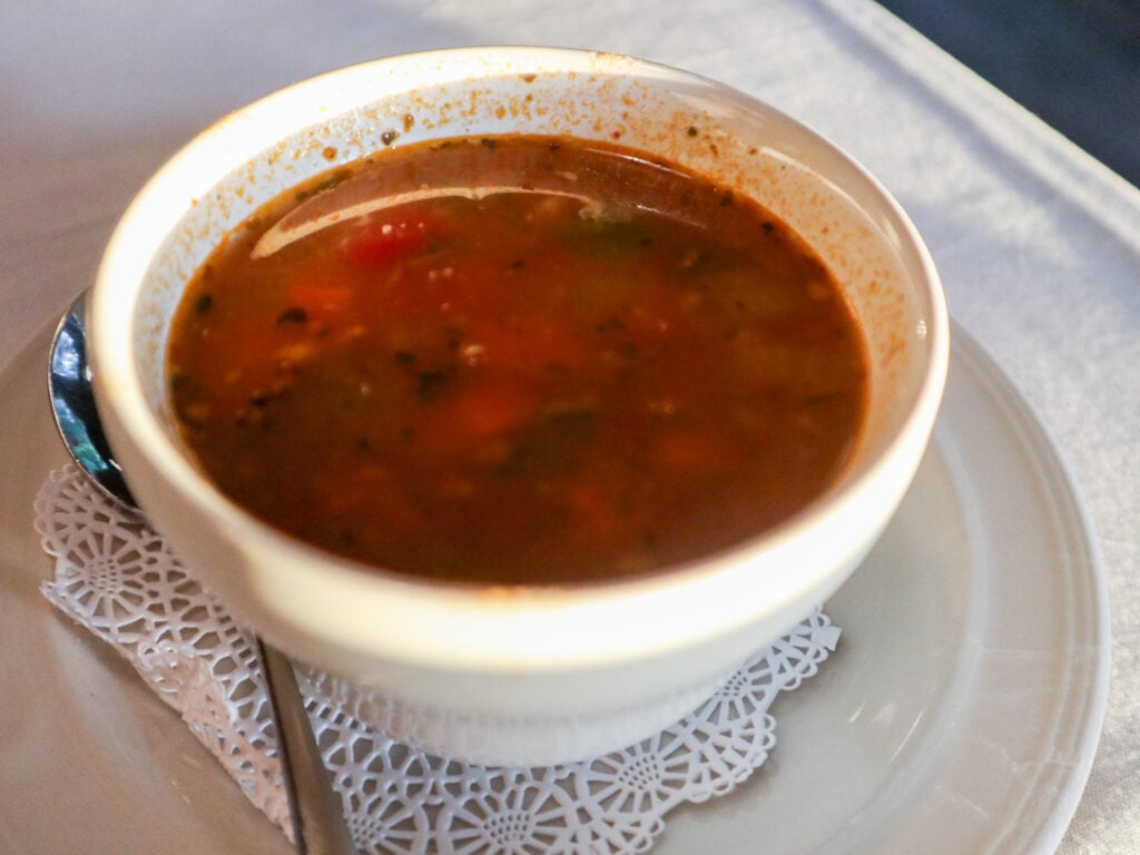 A white bowl of red soup.
