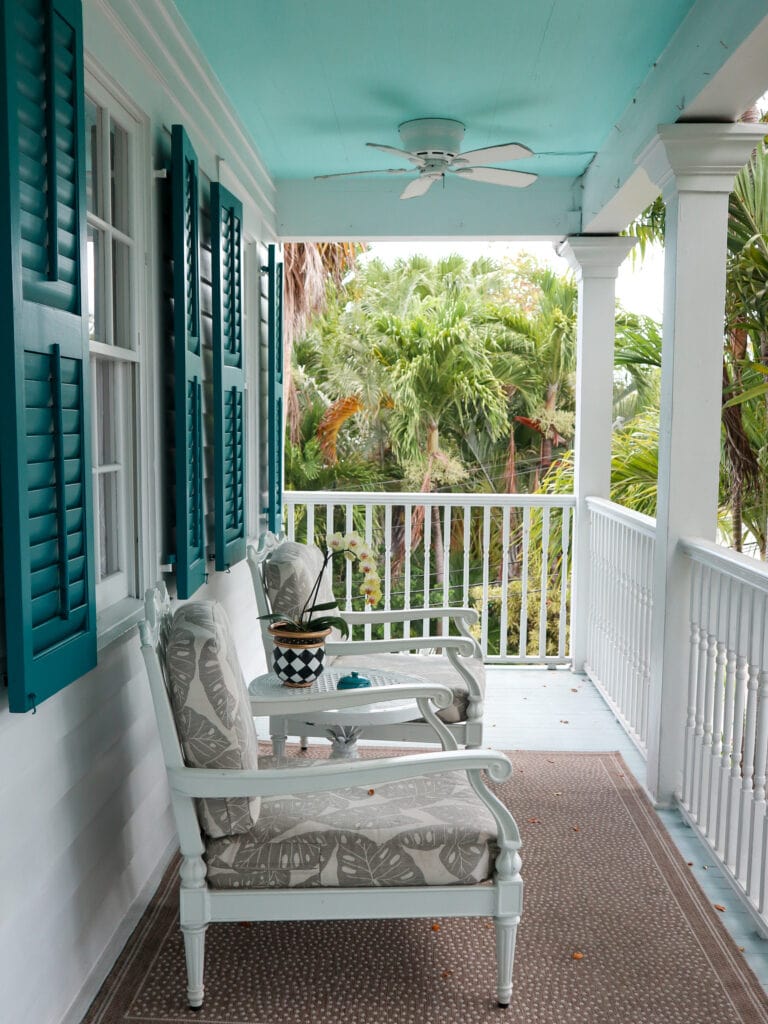 The green and white front porch of Garden Hotel Key West.