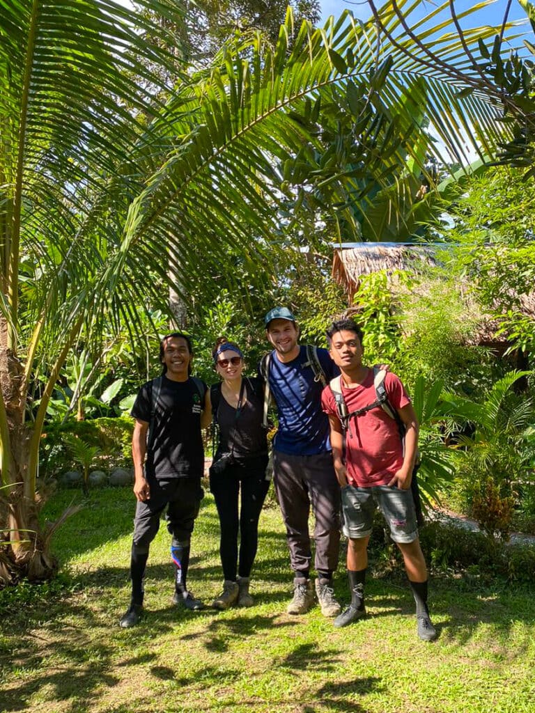 Sarah and Dan smile with their two Sumatran orangutan trekking guides