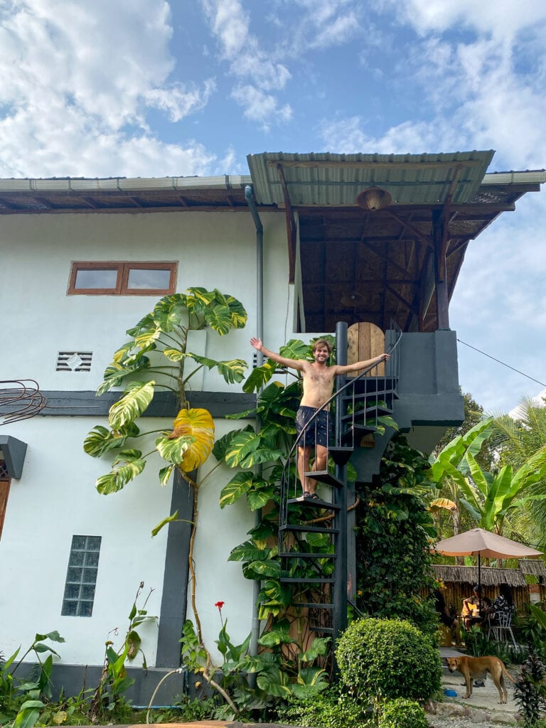 Dan waving from staircase at accommodation in Bukit Lawang