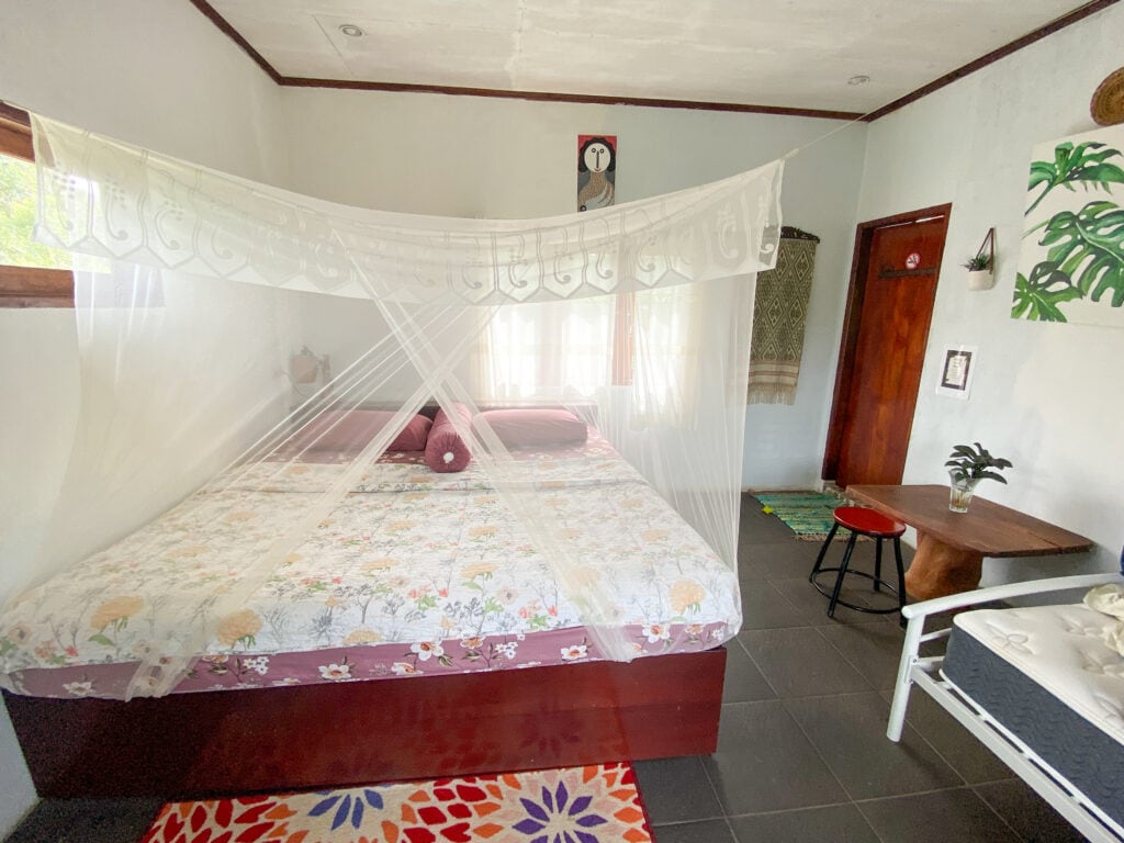 Large bed with mosquito net at Sumatra Orangutan Discovery Villa