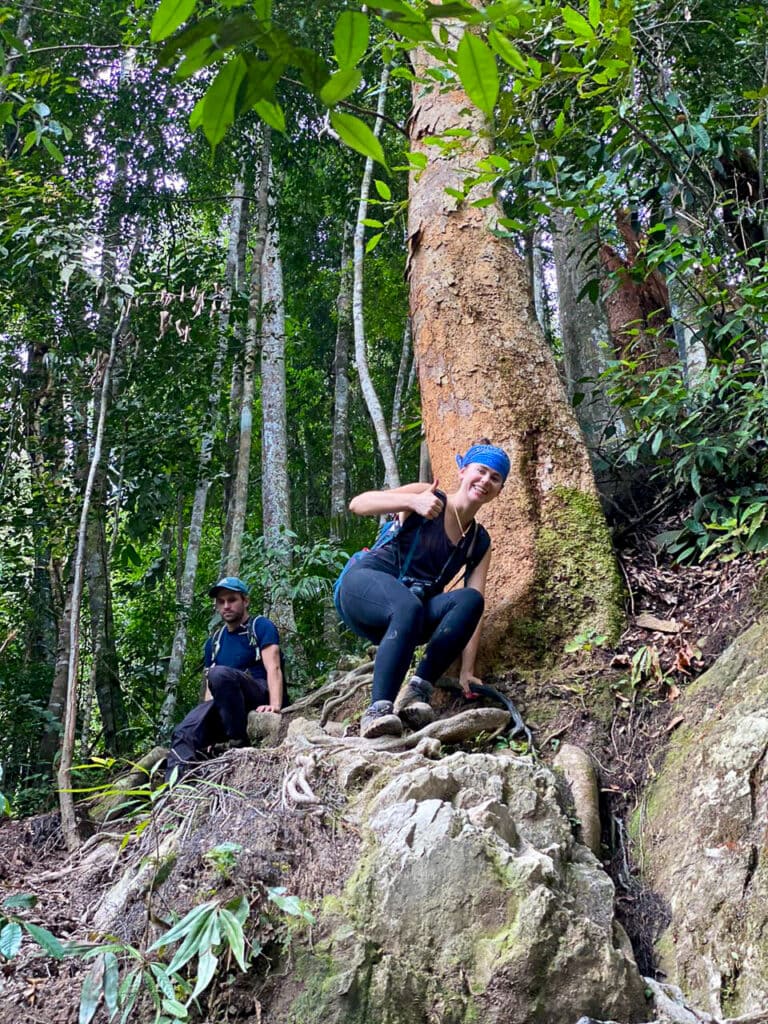 Sarah climbs down rocks in Sumatra jungle