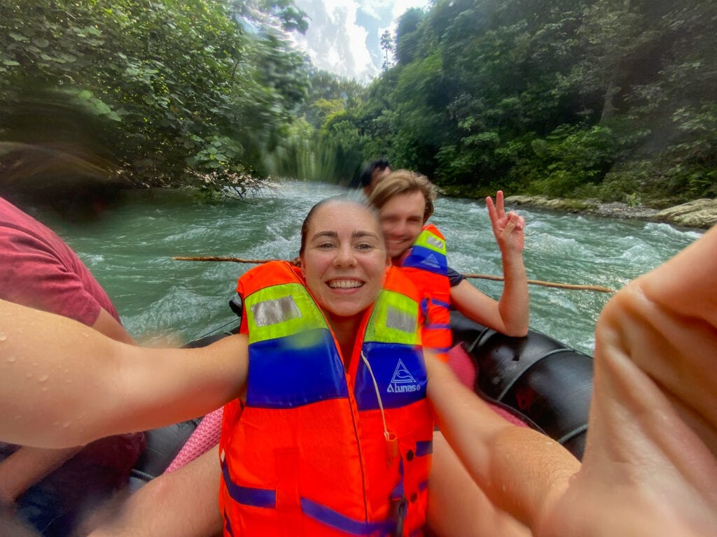 Selfie of Sarah and Dan in orange life vests in river tube.