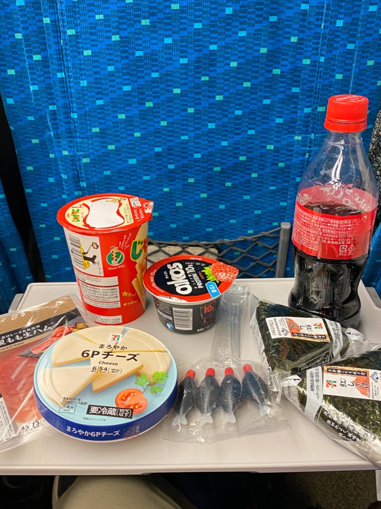 Bullet train tray table with food from 7/11.