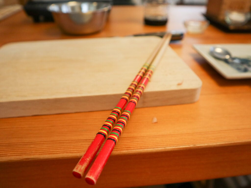 Two chopsticks on a shopping board.