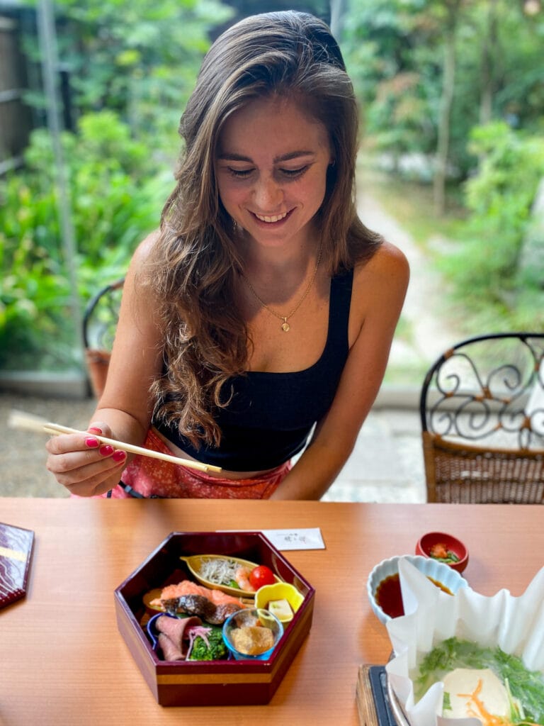 Sarah smiles with gluten free Japanese meal in Kyoto.