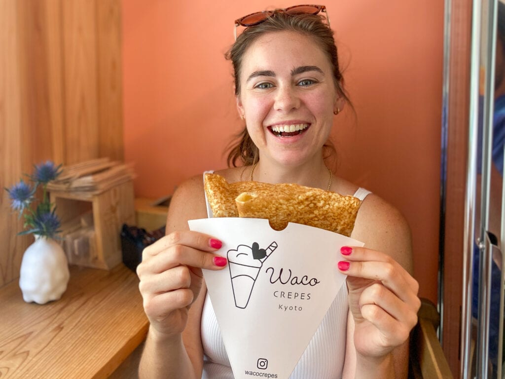 Sarah smiling and holding gluten free crepes from Waco Crepes Kyoto