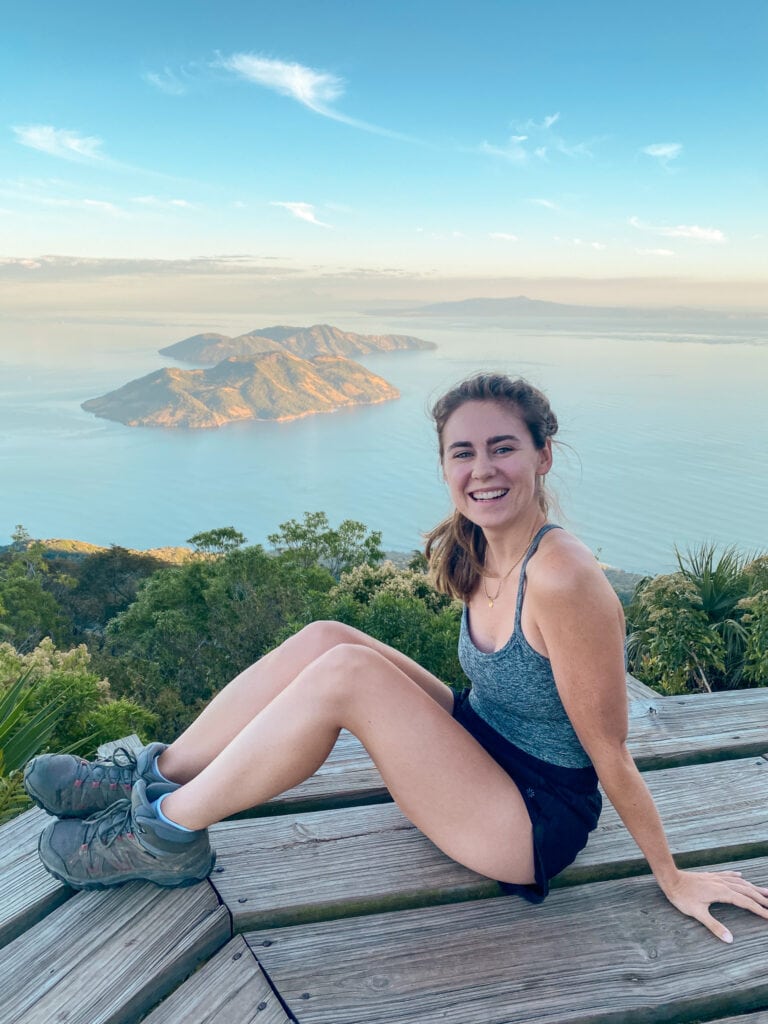 Sarah smiles on conchagua volcano in front of view of water and islands