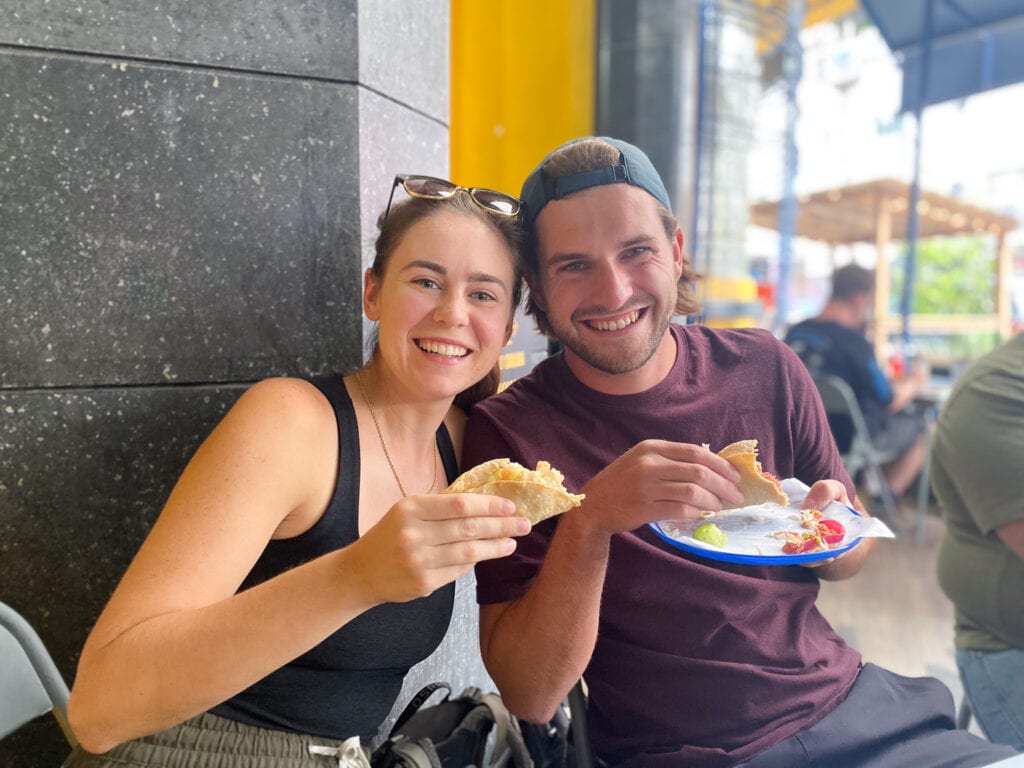 Sarah and Dan hold tacos and smile on the Eat Mexico City taco tour