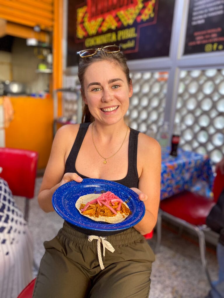 Sarah smiling with tacos on Mexico City taco tour