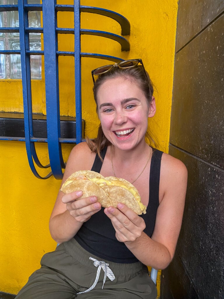 Sarah smiles and holds shrimp taco in Mexico City