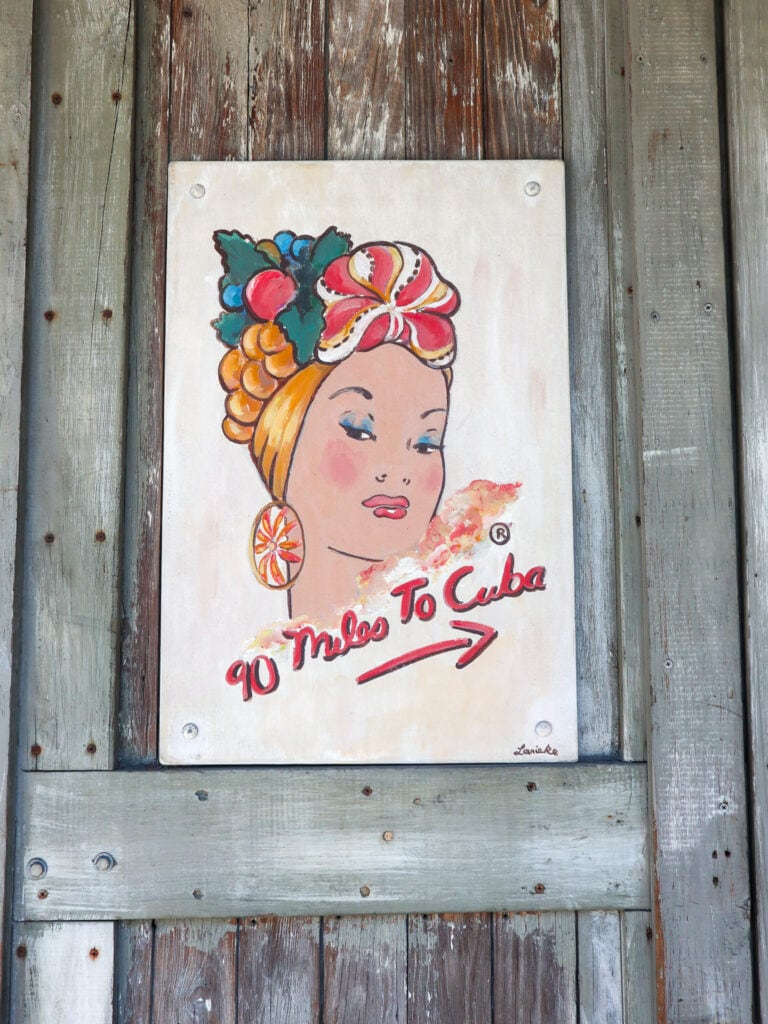 painted sign that reads 90 miles to cuba