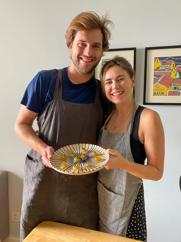 Sarah and Dan holding plate of tapioca dumplings during gluten free cooking class in Ho Chi Minh Vietnam.