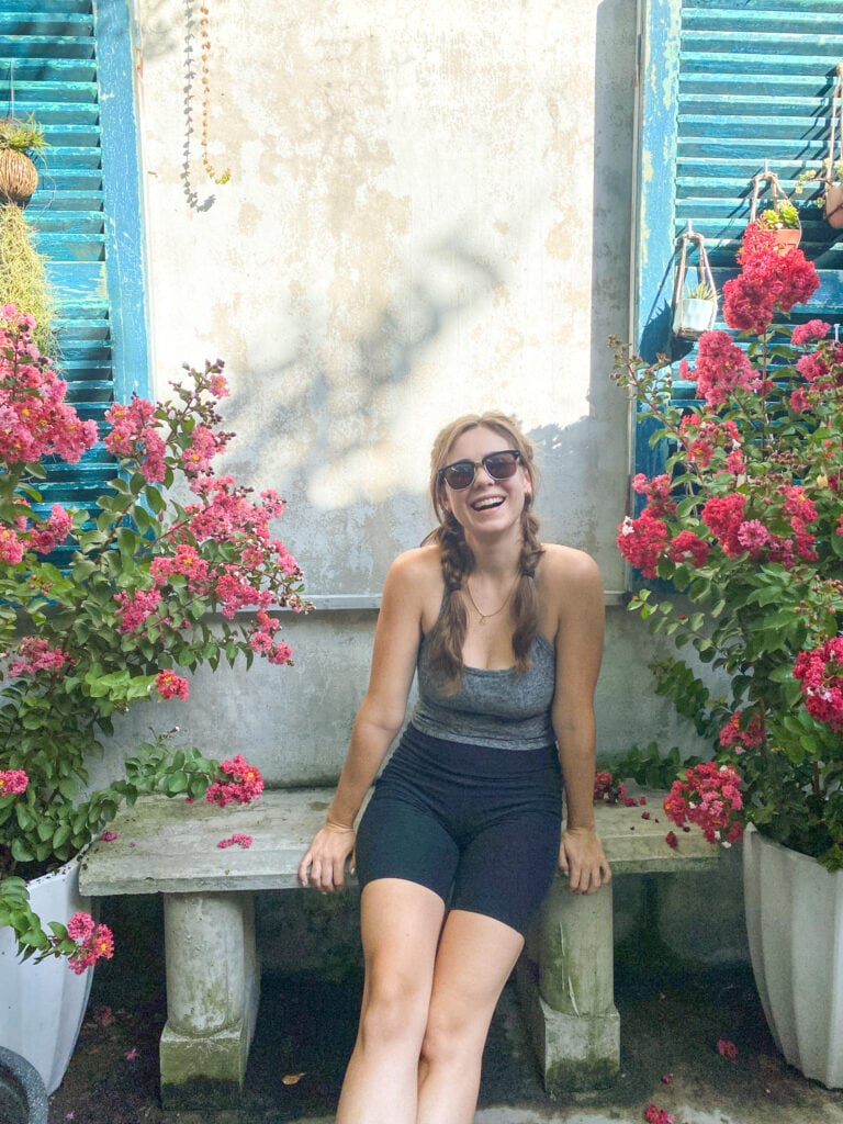 Sarah sitting on bench with flowers in Hoi An