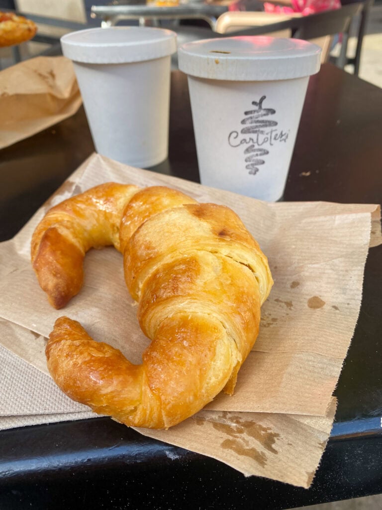 gluten free croissant and two paper coffee cups