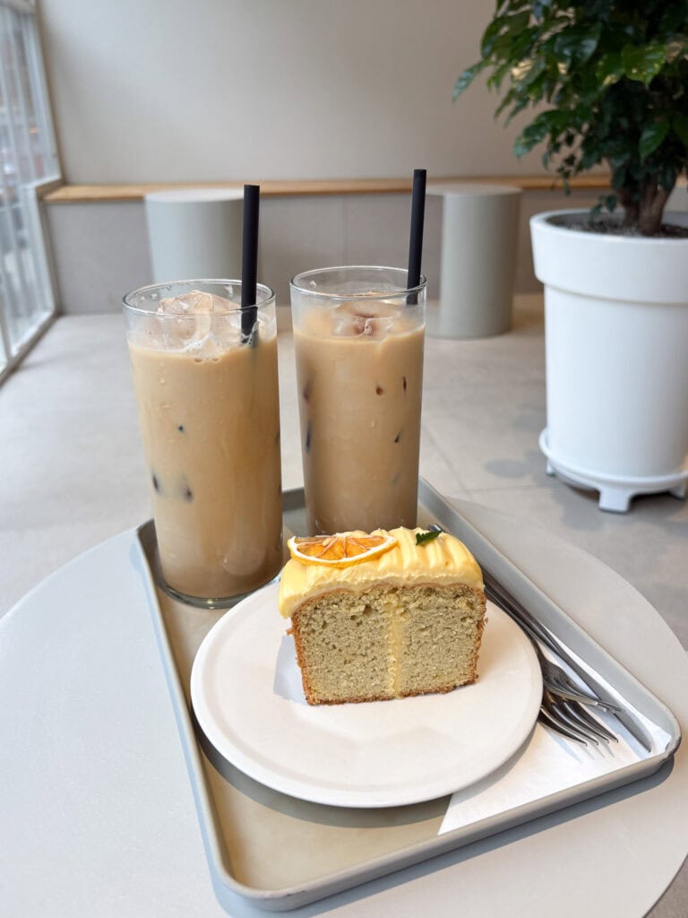 Table with two coffees and a gluten free lemon cake.