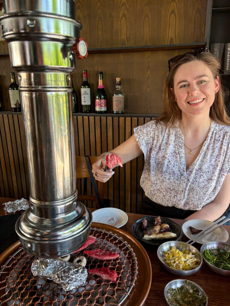 Sarah smiling while barbecuing in Seoul.