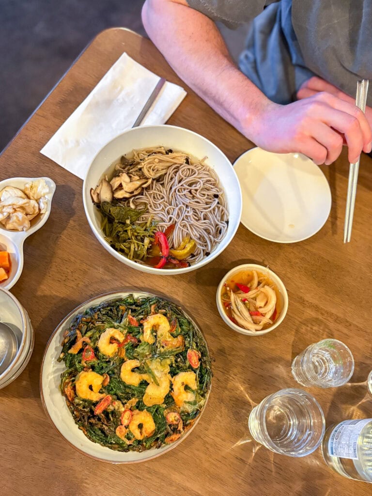 Overhead shot of table with gluten free Korean pancake and noodle bowl