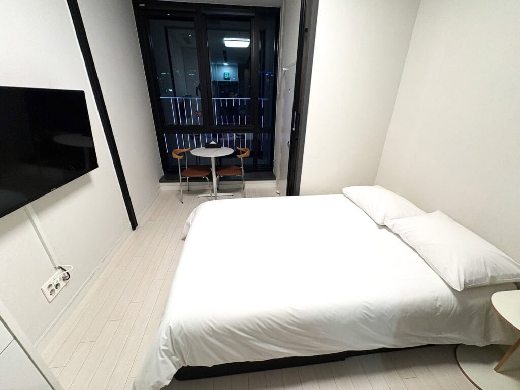 Modern hotel room with a balcony and minimalist decor.