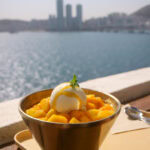 Mango bingsu on a balcony overlooking the Busan city skyline.
