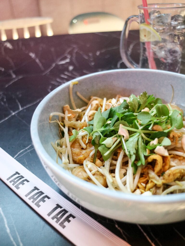 Delicious Asian noodle dish with fresh greens and bean sprouts in a bowl.