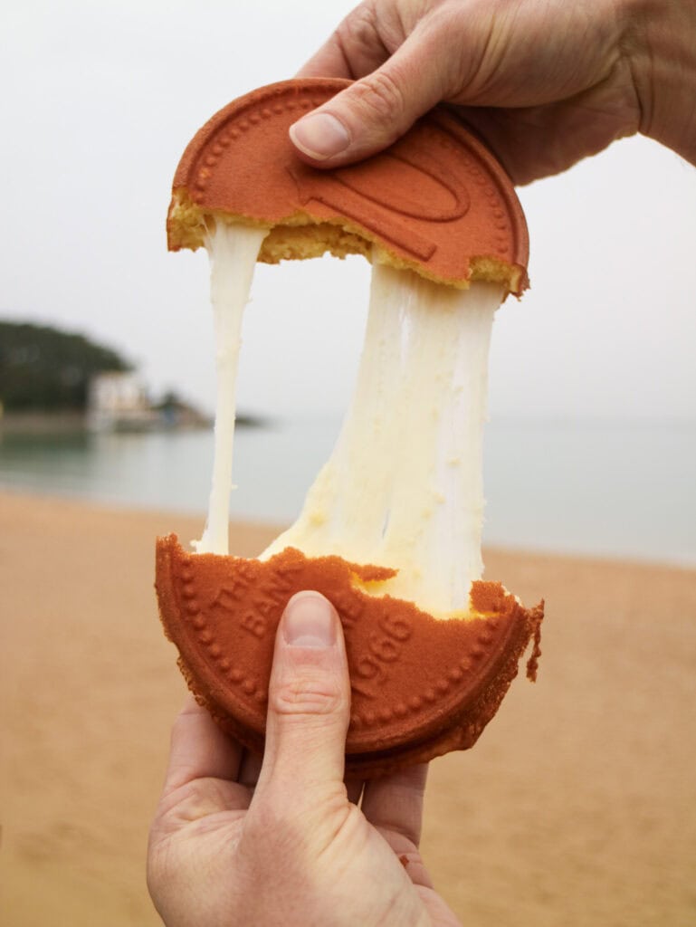 Cheese stretching out of a 10 won cake on a beach.