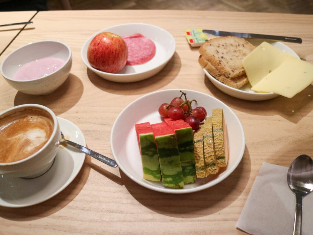 Assorted gluten-free snacks and beverages on a wooden table in Oslo.