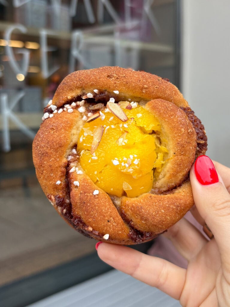 Gluten-free pastry with yellow filling and sugar topping in hand.