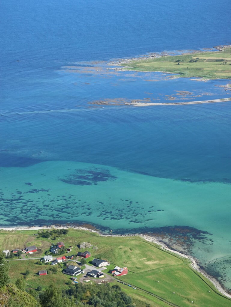 Scenic aerial view of Lofoten islands with turquoise waters and small village.