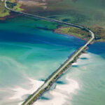 Scenic aerial view of a bridge crossing a colorful fjord in Norway.
