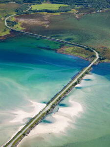 Scenic aerial view of a bridge crossing a colorful fjord in Norway.