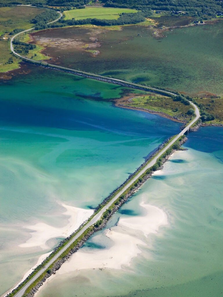 Scenic aerial view of a bridge crossing a colorful fjord in Norway.