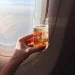 Celebratory drink on airplane with view outside window.