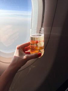 Celebratory drink on airplane with view outside window.