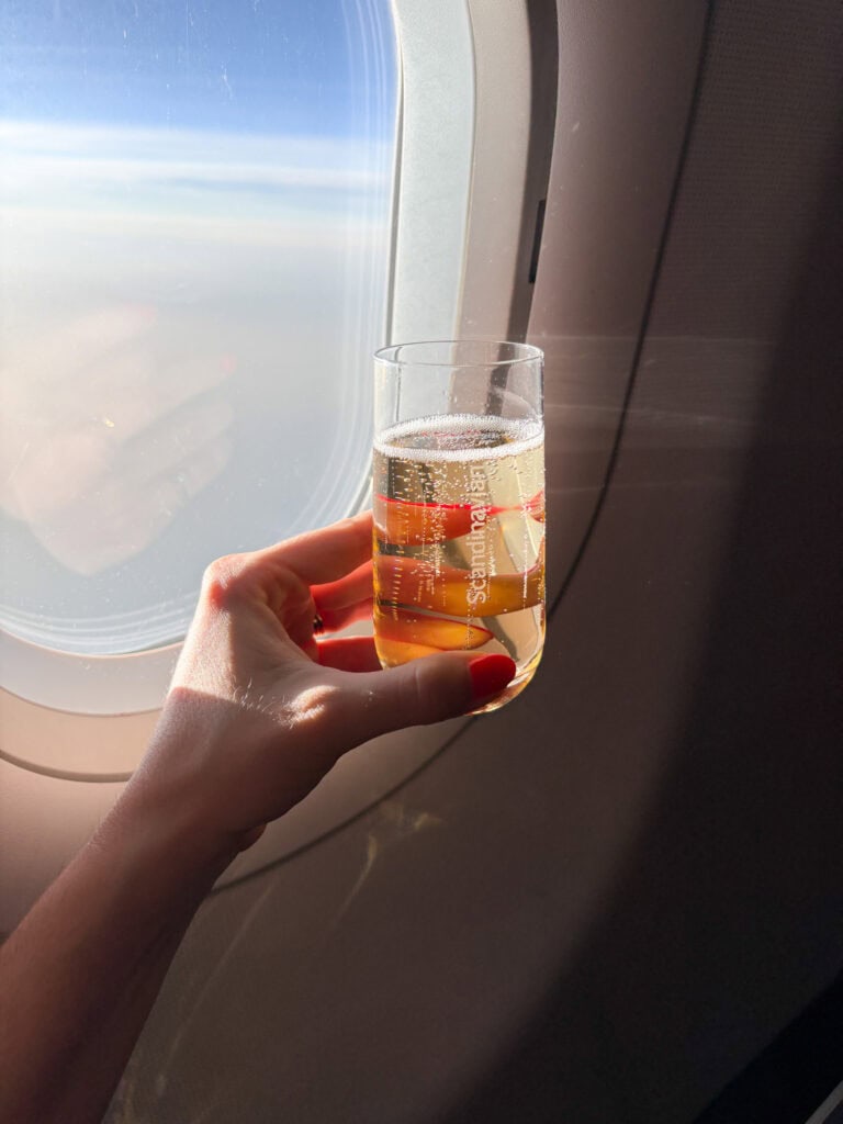 Celebratory drink on airplane with view outside window.