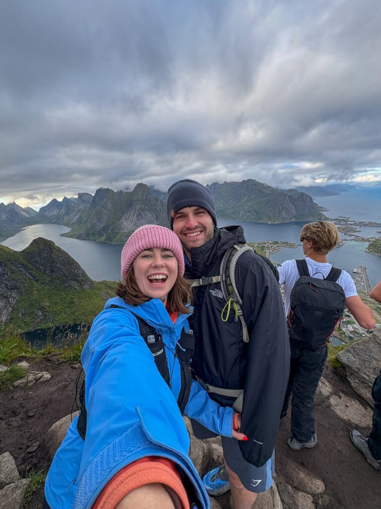 Hikers enjoying panoramic view of Lofoten mountains and fjords in Norway.