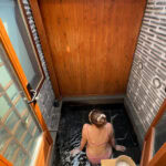 Woman enjoying a traditional Korean jjimjilbang bath experience.