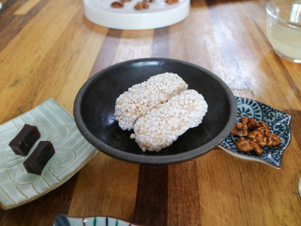 Traditional Korean rice cakes with nuts on a wooden table.