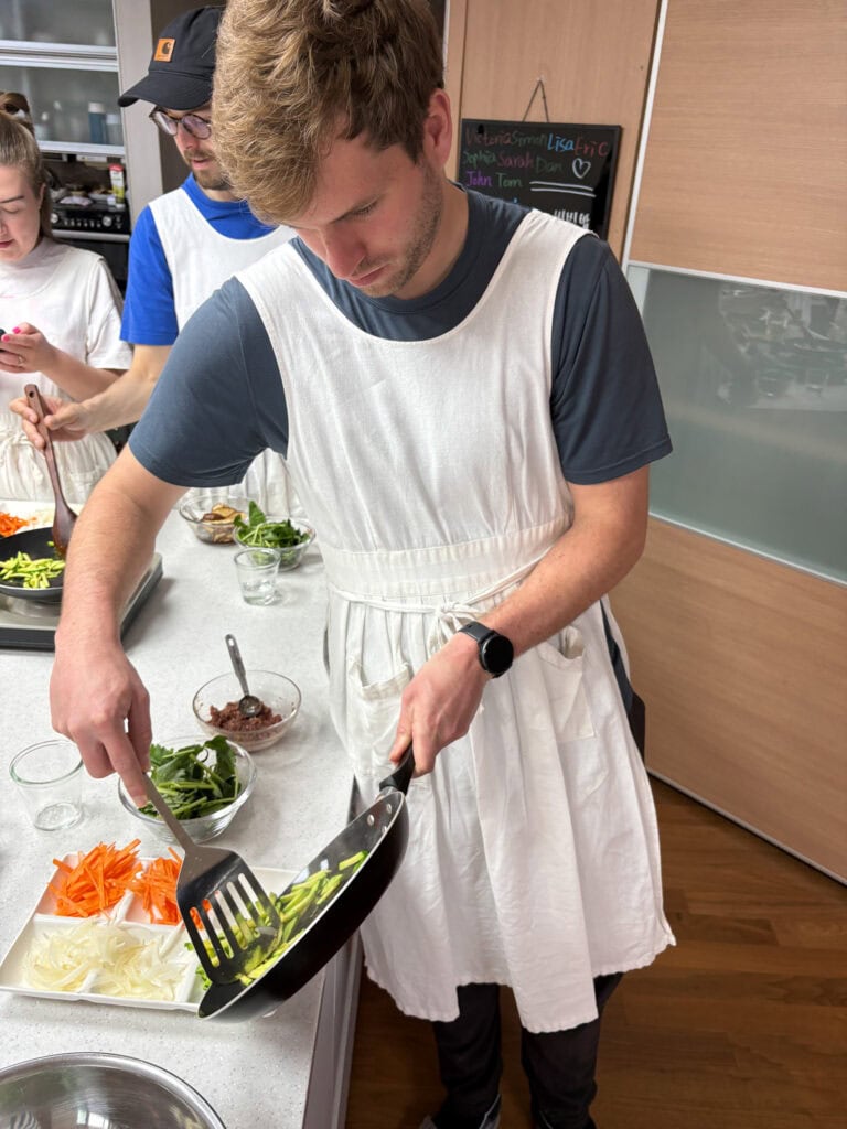 Young man preparing vegetables at a cooking class in Busan, South Korea.