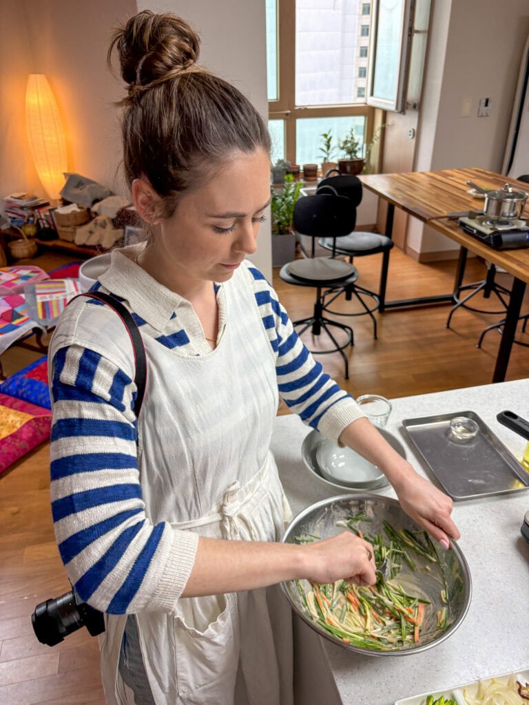 Woman preparing fresh vegetables in a modern kitchen for a cooking class.