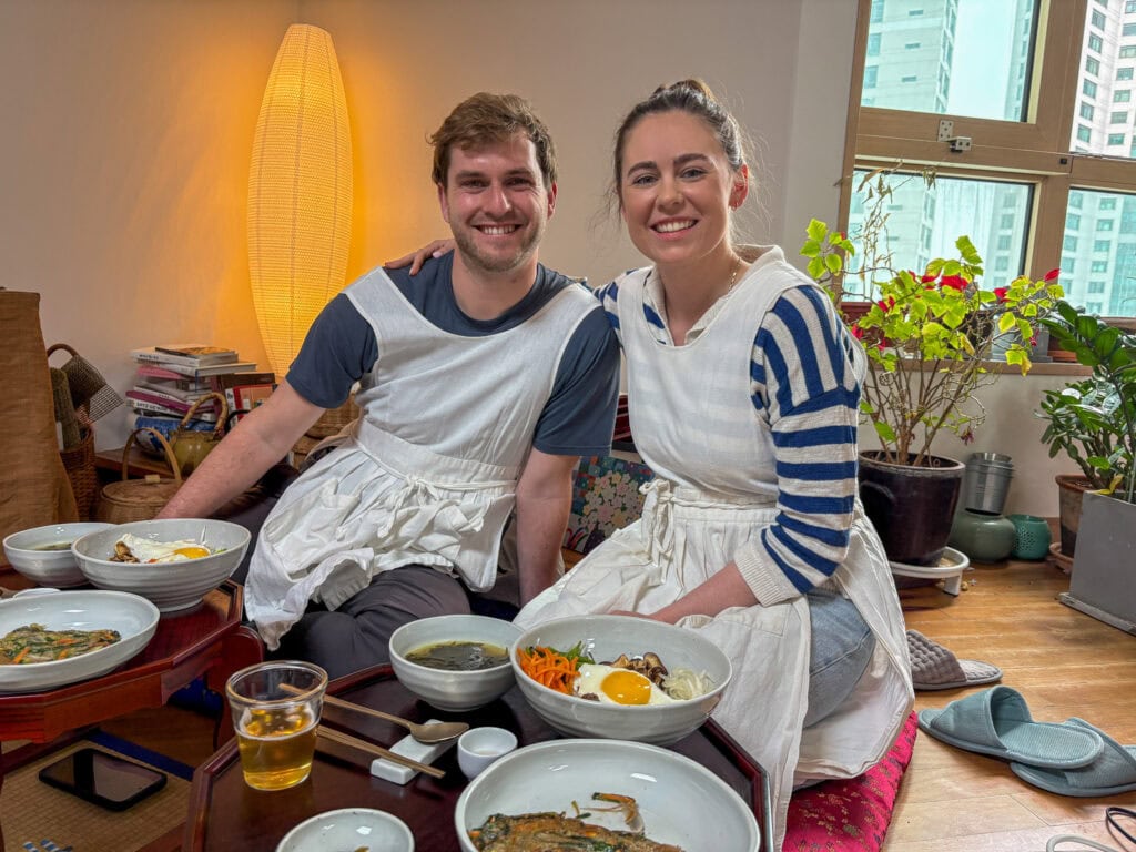 Happy couple enjoying Korean dishes during a cooking class in Busan.