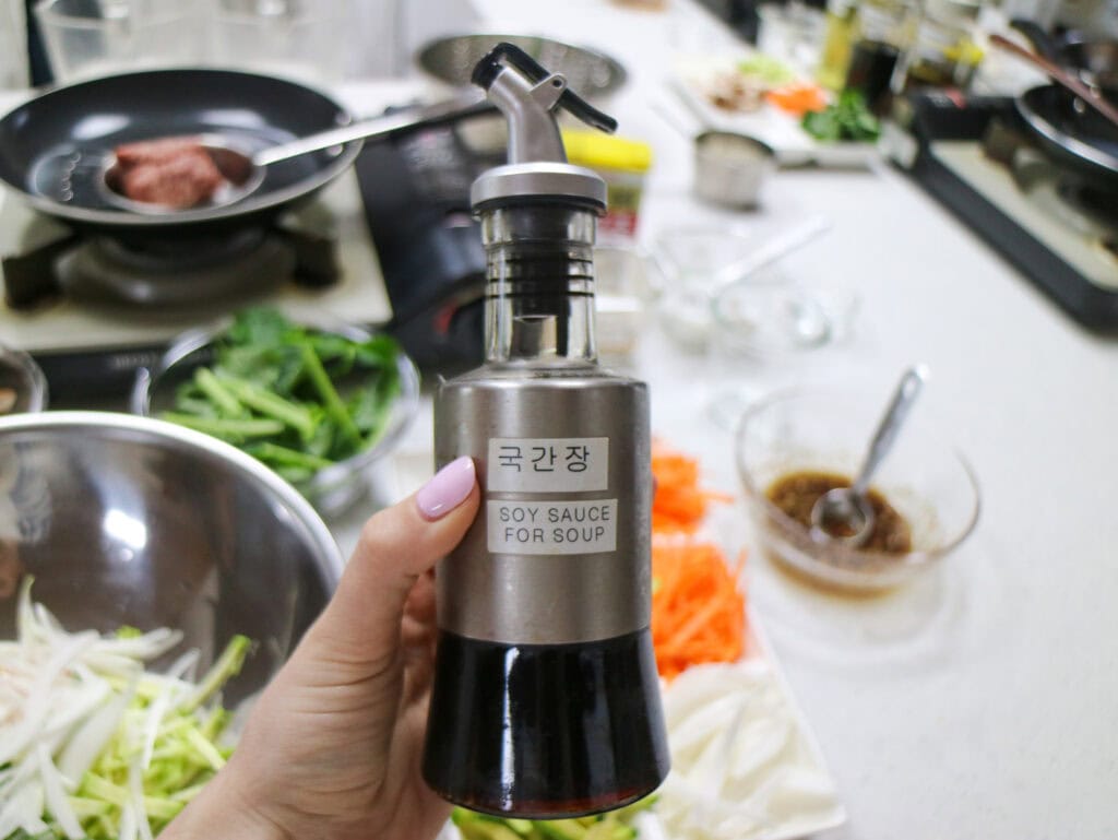 Soy sauce dispenser in a busy Korean cooking class kitchen.