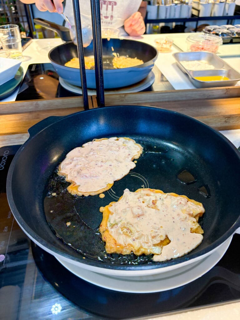 Cooking Korean pancakes in a professional kitchen during a class.