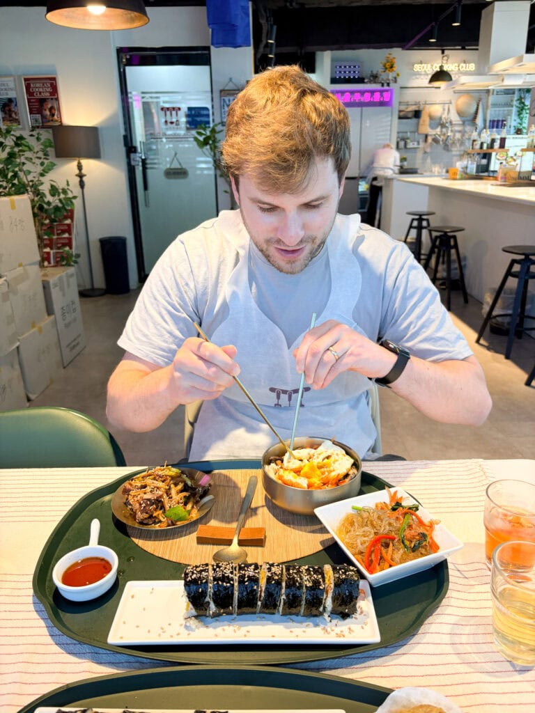 Young man enjoying Korean dishes at a restaurant in Seoul.