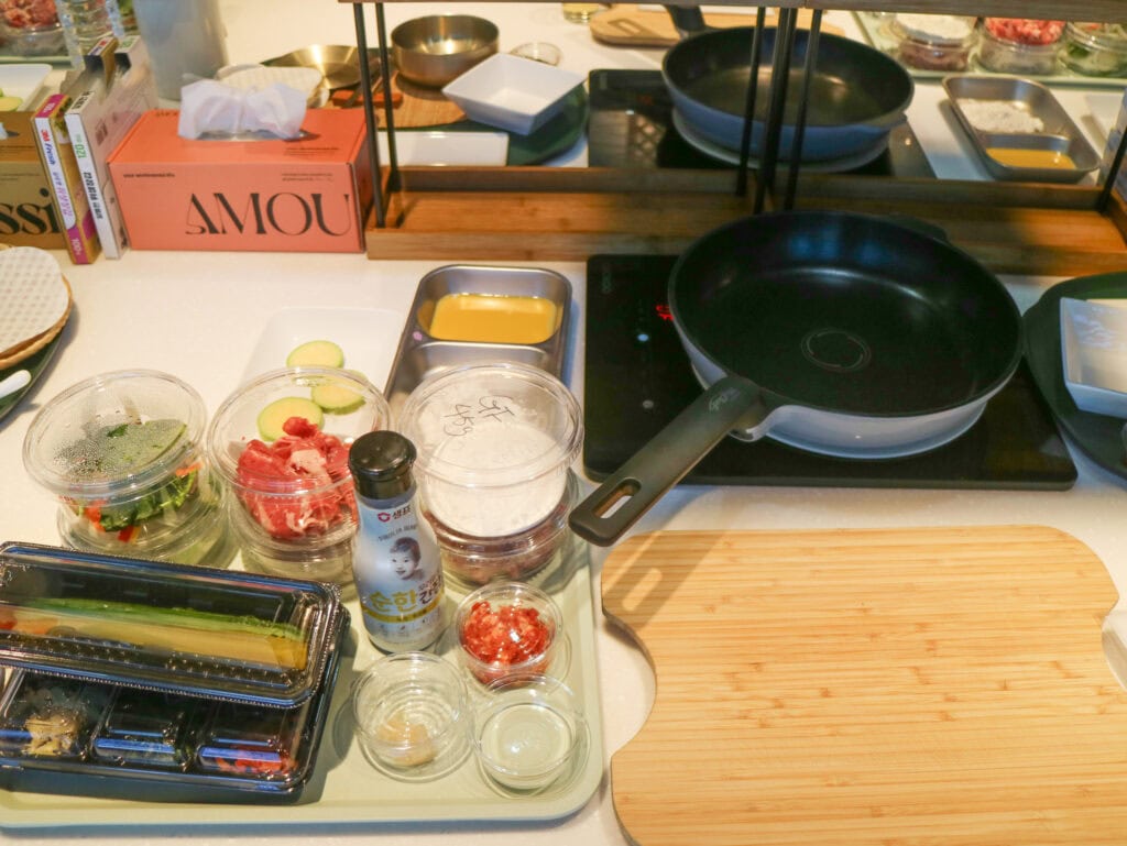 Korean cooking ingredients and utensils on a kitchen counter for a cooking class.
