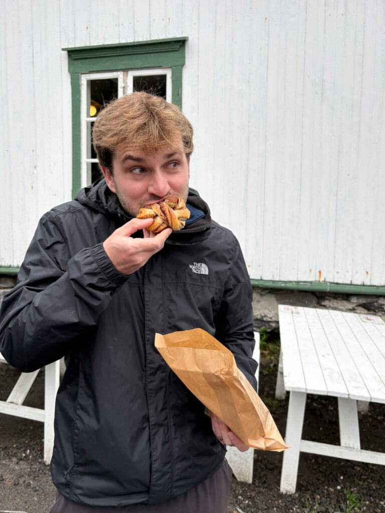 Young man enjoying a sandwich outdoors in Lofoten, Norway.